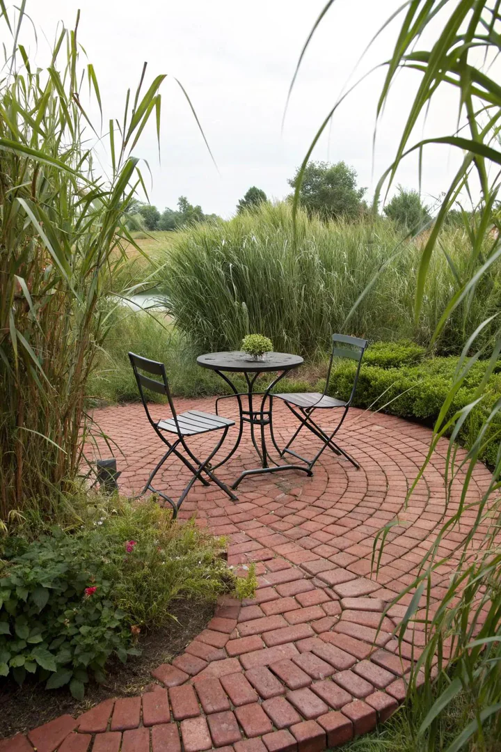 small circular brick patio with a running bond pattern and two Adirondack chairs in a backyard corner