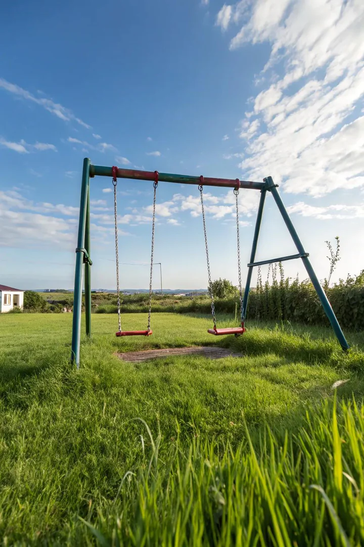 wooden swing set with a metal trapeze bar and gym rings hanging next to a belt swing