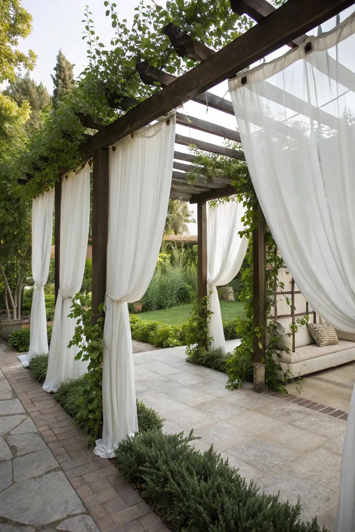 Flowing outdoor curtains hung from a pergola beam with grommet tops and a stainless steel rod