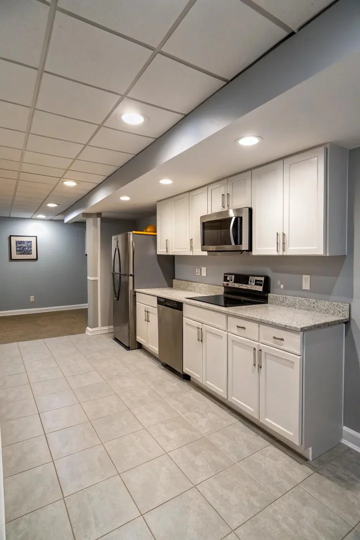 Basement kitchen with no upper cabinets using open shelves and a tiled accent wall