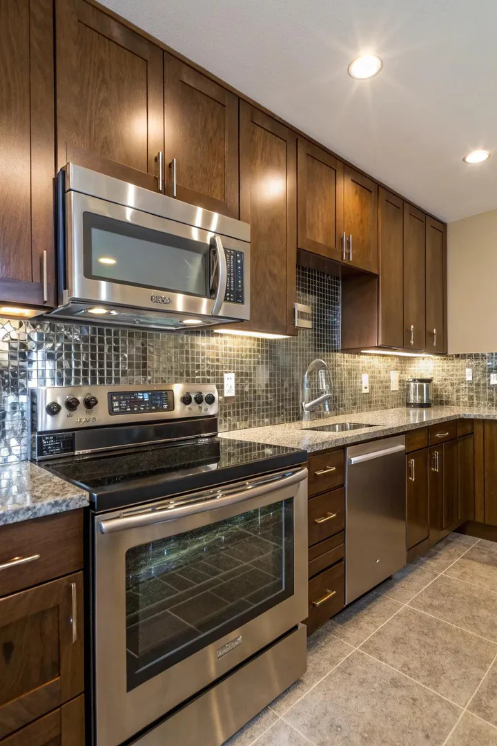 Reflective backsplash surfaces in a windowless kitchen.
